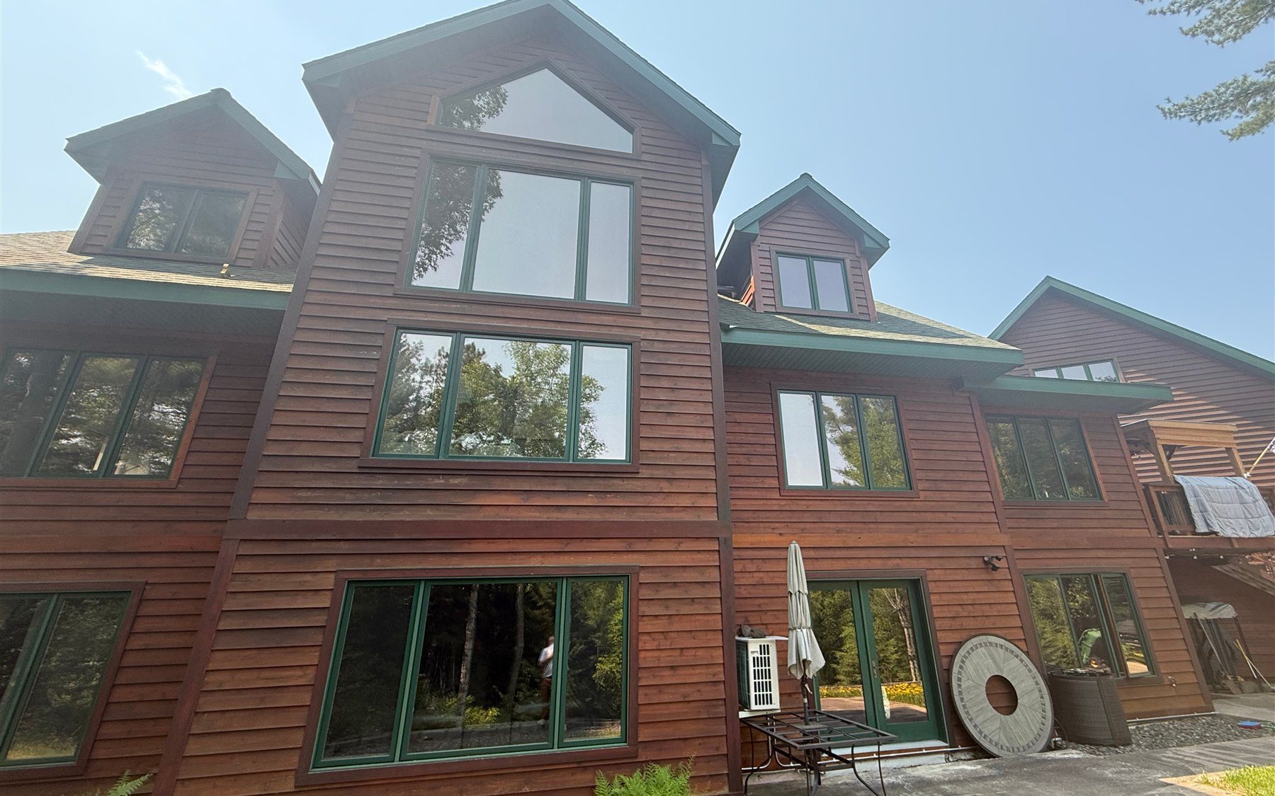 Before: reddish-brown siding with green trim before repaint