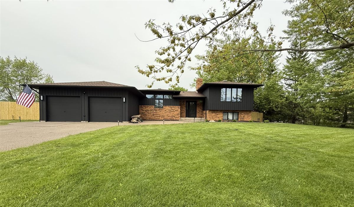 Charcoal exterior with brick accent on split-level home
